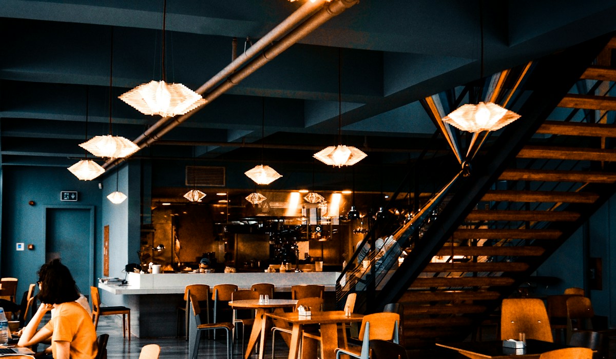 Balcão de restaurante moderno iluminado com taças e atendimento sofisticado