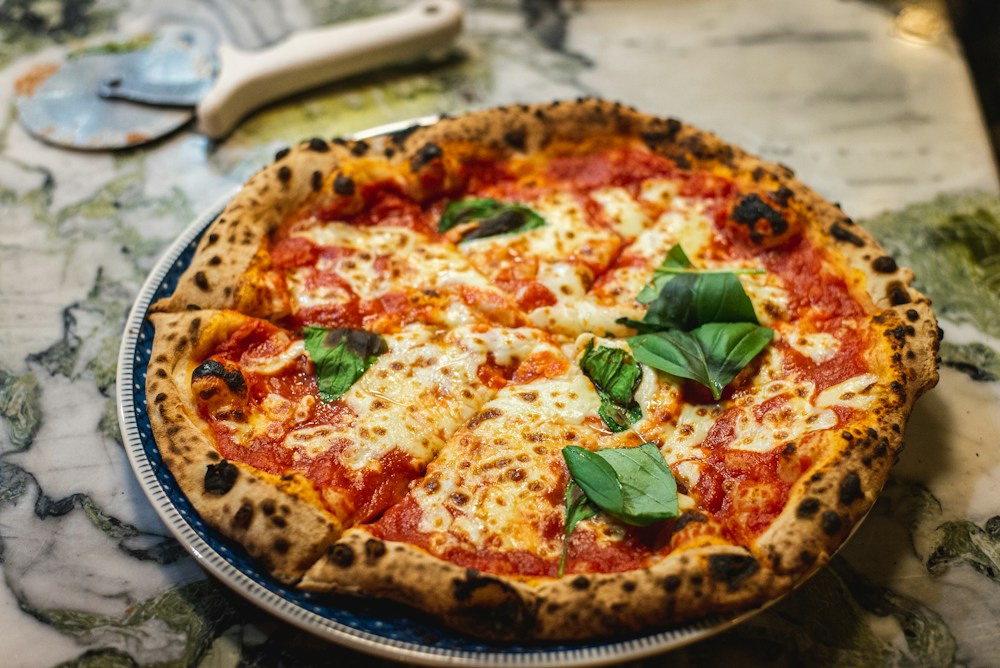 Pizza artesanal saindo do forno a lenha com queijo derretido representando pedidos recorrentes de alto valor