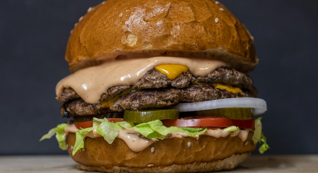 Hambúrguer artesanal gourmet servido com batatas rústicas para cardápio digital de delivery