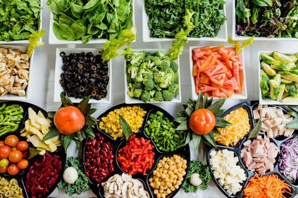 Bancada culinária com vegetais e ingredientes frescos selecionados para preparo de pedidos no food service