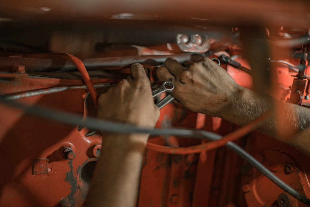 Especialista em reparação automotiva ajustando componentes do motor com ferramentas calibradas