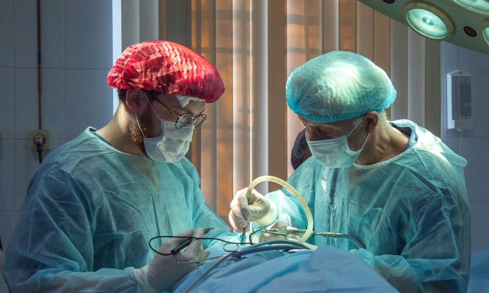 Médico segurando tablet analisando fluxo de triagem e confirmações automatizadas de pacientes