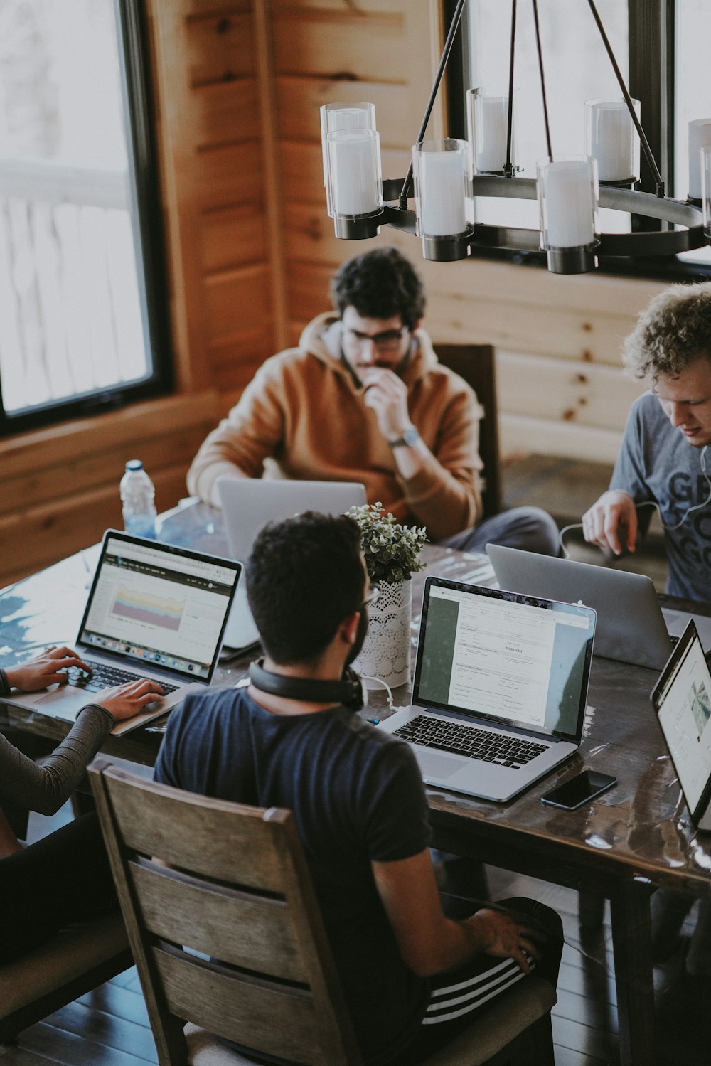 Executivos fechando contrato B2B em mesa de conferência com aperto de mão profissional