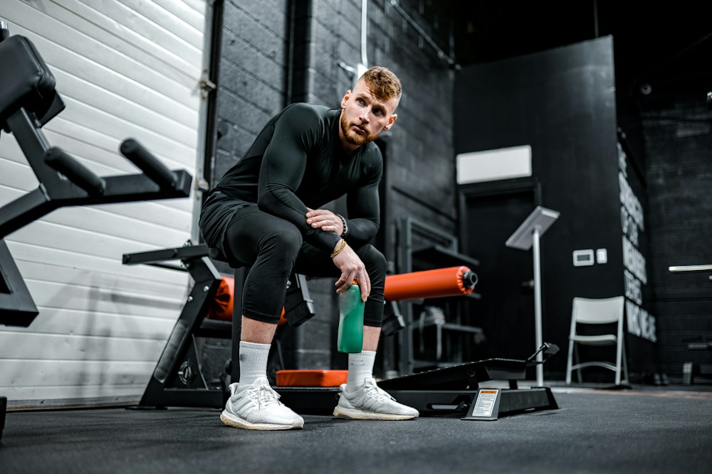 Personal trainer auxiliando praticante em execução correta de exercício de musculação
