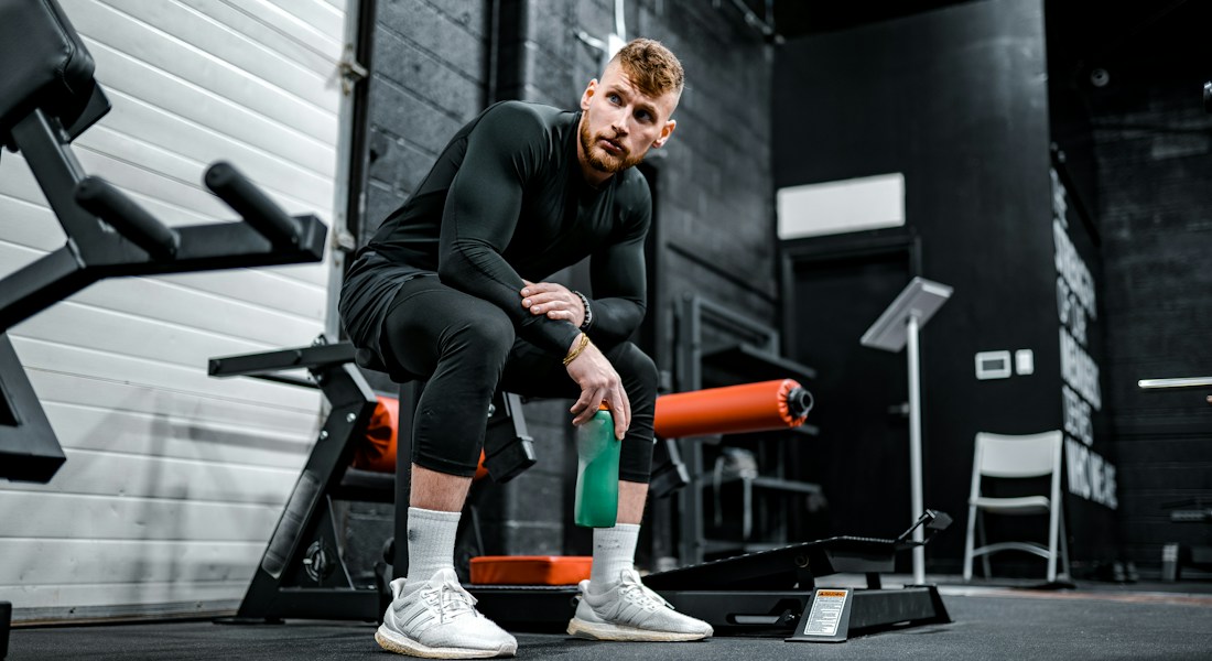 Instrutor e personal trainer acompanhando postura e treino de aluno com dedicação e atendimento consultivo humanizado