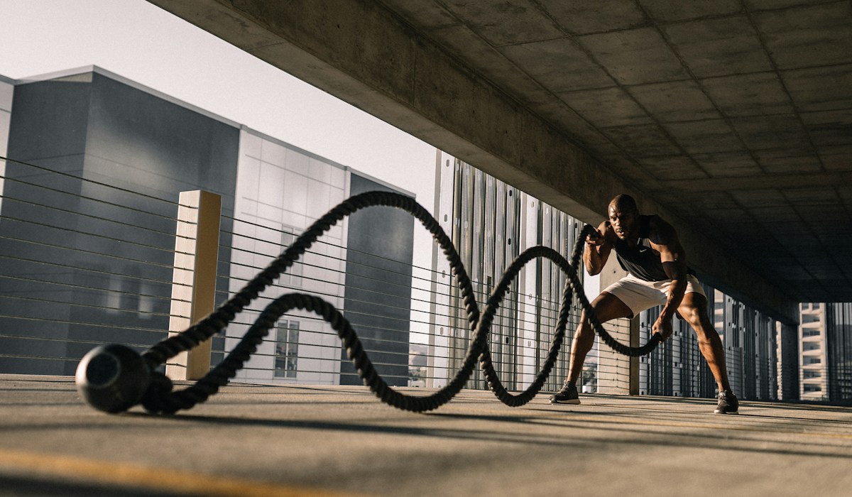 Treinador orientando aluna durante exercício funcional para elevar engajamento e retenção