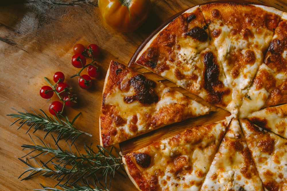 Pizza artesanal saindo do forno com queijo derretido e manjericão fresco representando alta gastronomia delivery